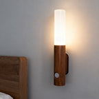 Wooden wall sconce with a white light fixture on a gray wall.