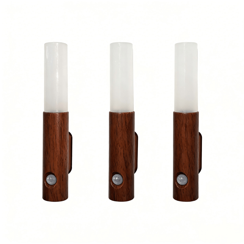 Three wooden wall sconces with white cylindrical shades on a white background
