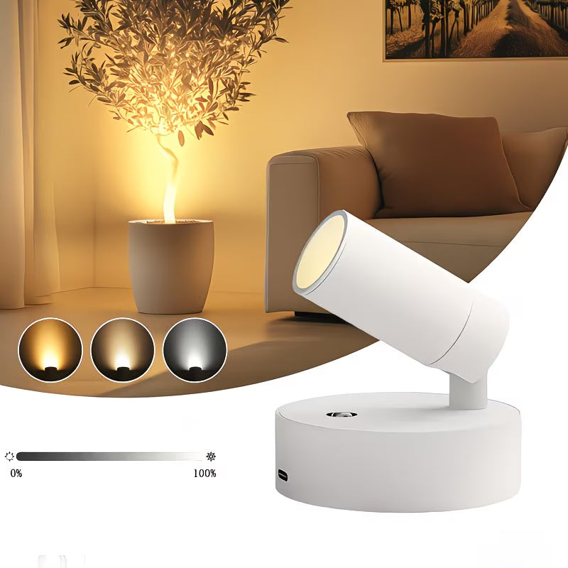 White adjustable spotlight in a living room setting with a plant and sofa.