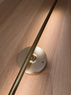 Brass wall-mounted light fixture on a wooden surface