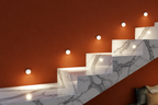 Marble staircase with orange wall and recessed lighting