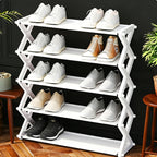 White shoe rack with various shoes on a wooden floor against a black wall.