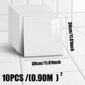 White square tiles with dimensions and quantity information on a tiled floor background